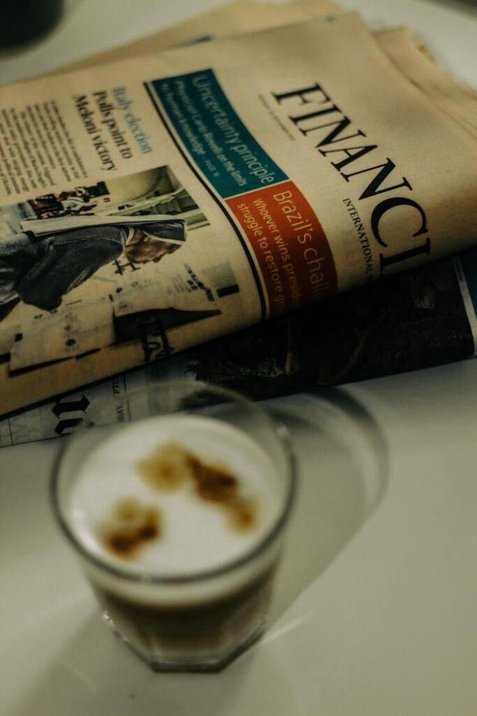 pexels photo 14091143 Close-up of a financial newspaper and coffee cup on a desk, ideal for finance themes.