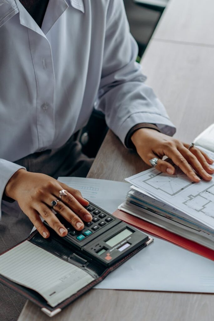 pexels photo 8297220 Accountant calculates finances with a calculator and documents on a desk.
